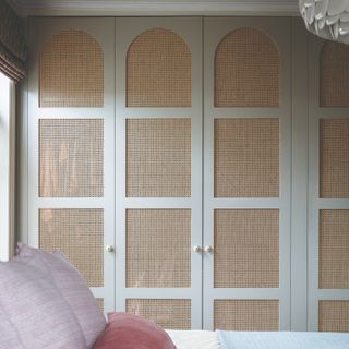 Light blue and rattan style built in bedroom closet, double bed
