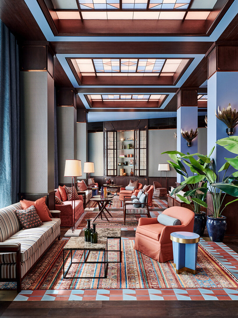 Salmon pink, rich brown and powder blue interior with square skylights and bright green foliage