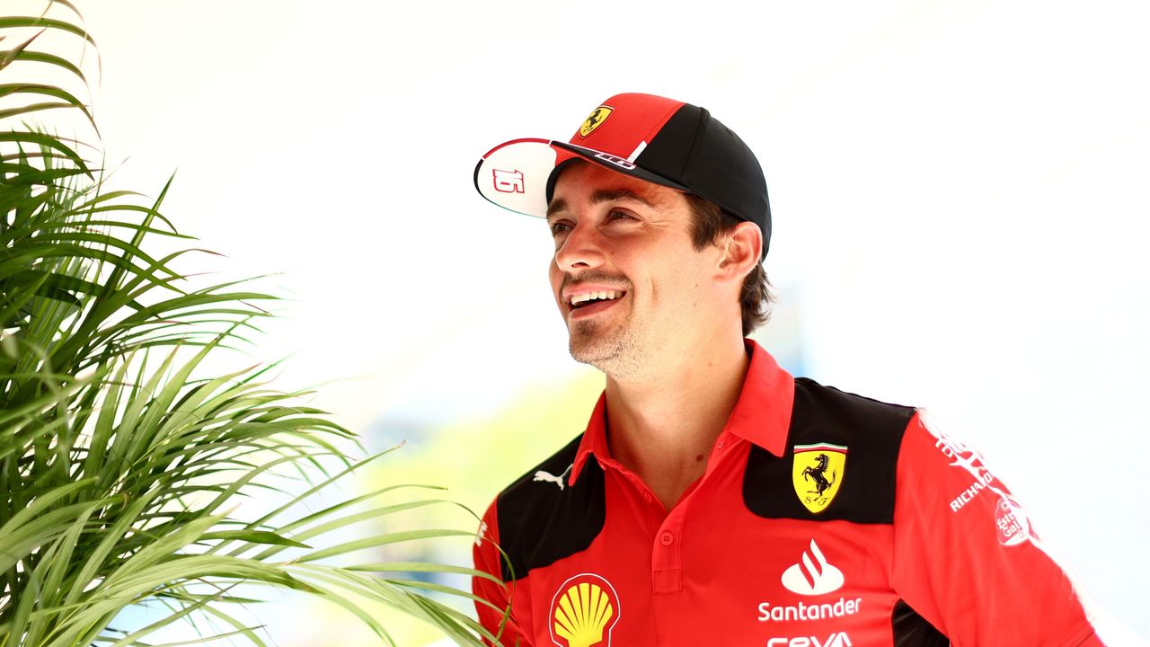 Charles Leclerc&#039;s living room is cozy and elegant. Here is a picture of the driver in a red and black shirt and hat next to a plant