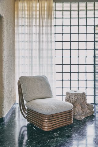 Rattan chair by Gabriella Crespi with white upholstered seat and back, from Gubi