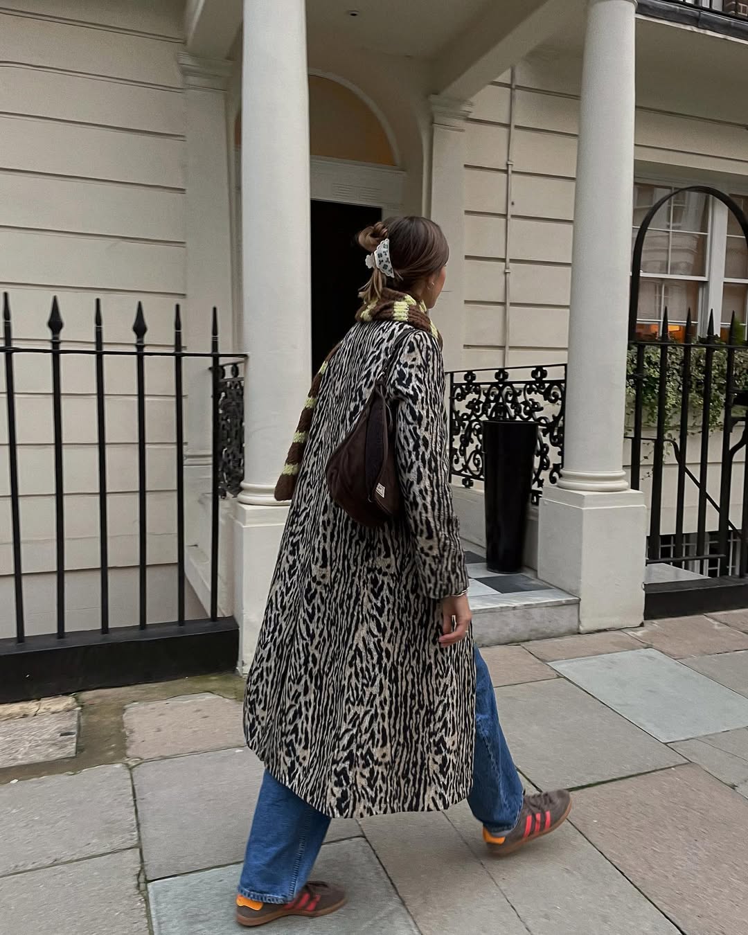 @poppyalmond wearing animal print coat with jeans and trainers