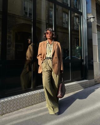 French woman wearing a brown blazer and olive green pants