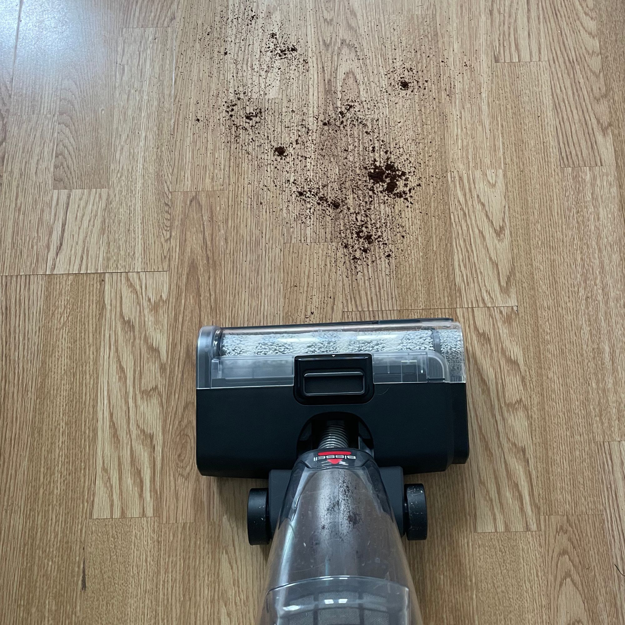 Bissell Crosswave Omniforce Edge on laminate floor with coffee grounds in front of it