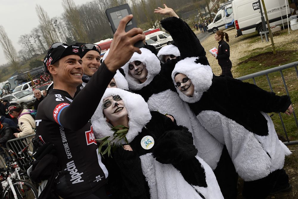 Warren Barguil takes a selfie with people dressed as pandas, on March 10, 2015, before taking the start of the second stage of the 73rd edition of the Paris-Nice