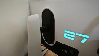 An Alienware AW2723DF monitor sitting on a wooden desk