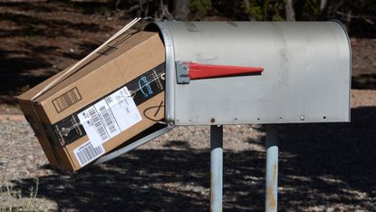 An Amazon package stuffed into a mail box