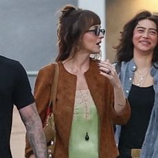 Dakota Johnson and Odessa A'zion attended a performance by St. Vincent in Los Angeles, California. Johnson wore a light green slip dress paired with a brown jacket and black flats.