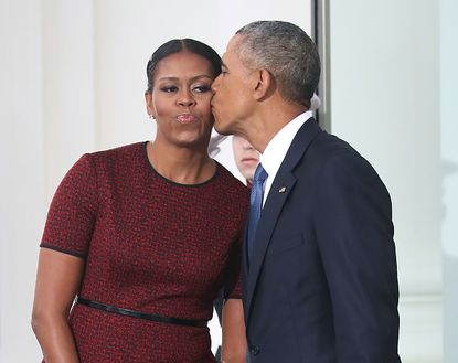 Barack Obama kisses Michelle Obama while departing from the White House.