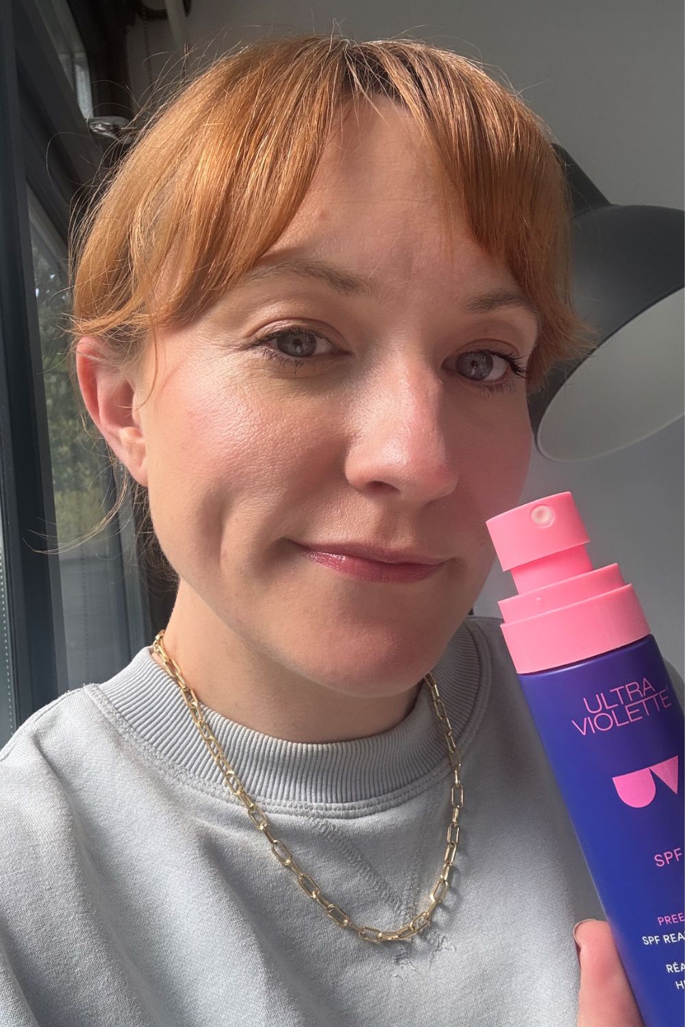 matilda with a bottle of ultra violette preen screen reapplication mist