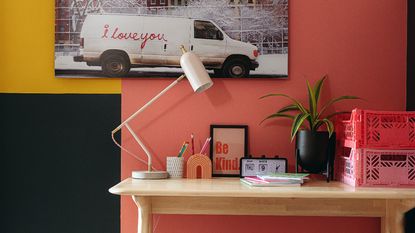 Wooden desk and chair, vase of dried flowers, wall art