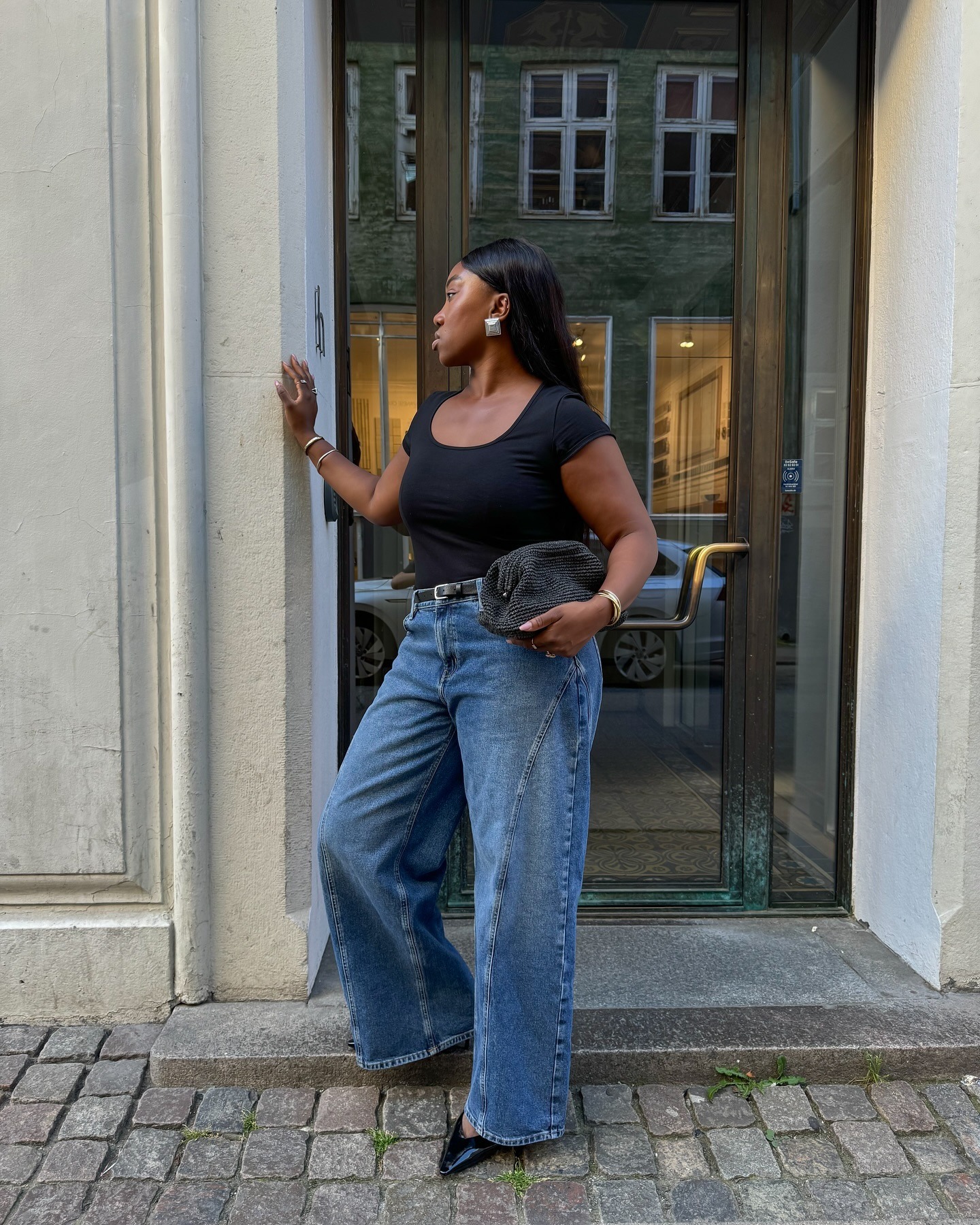 Woman in black top and wide-leg jeans