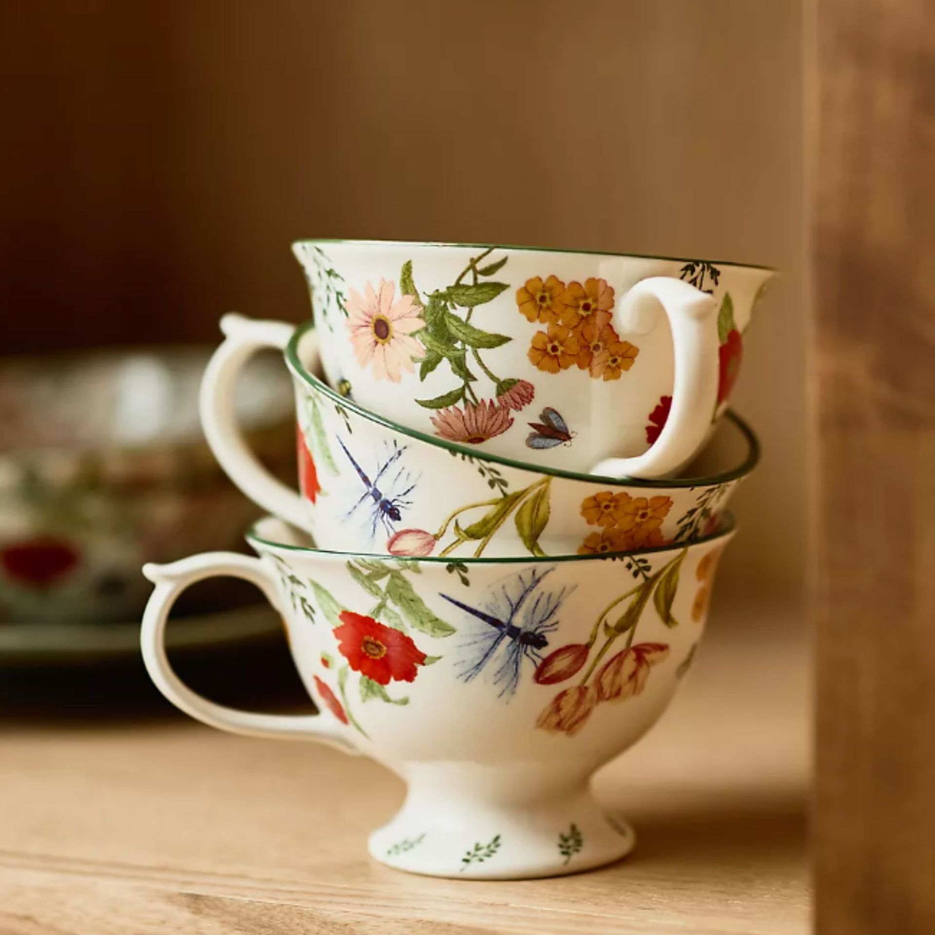 Stack of three teacups with vintage style botanical designs on them