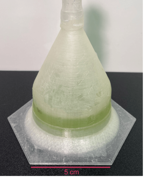 A vial of green liquid on a hot plate