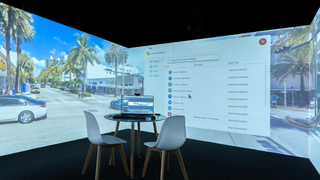 Two chairs surround a table with a laptop projecting its screen onto two immersive displays powered by Igloo's ICE. 