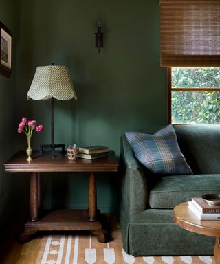 Dark green living room with dark green sofa ad white and jute rug