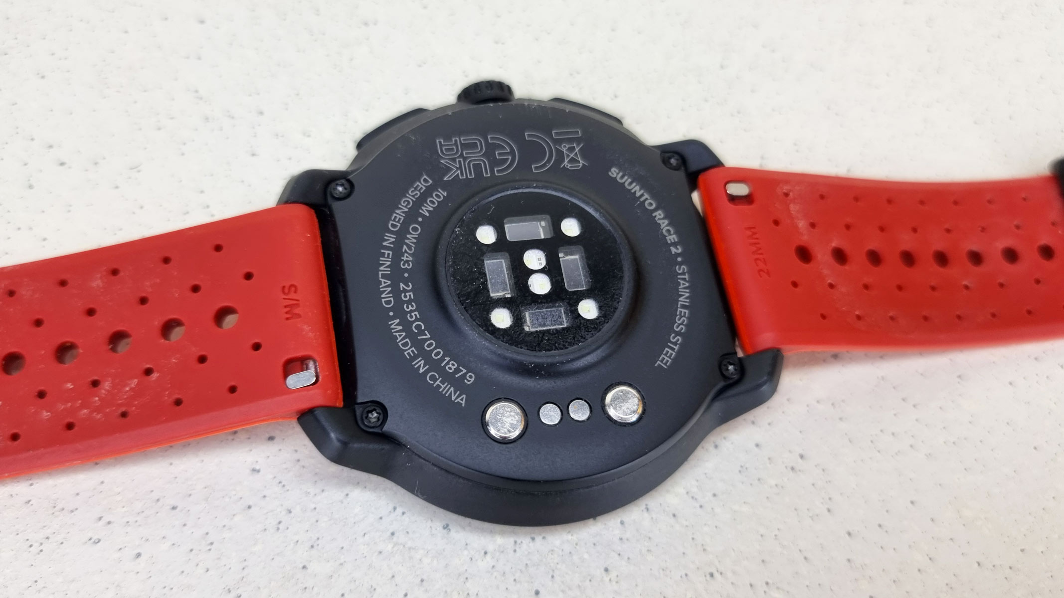 The back of the Suunto Race 2 with orange strap.