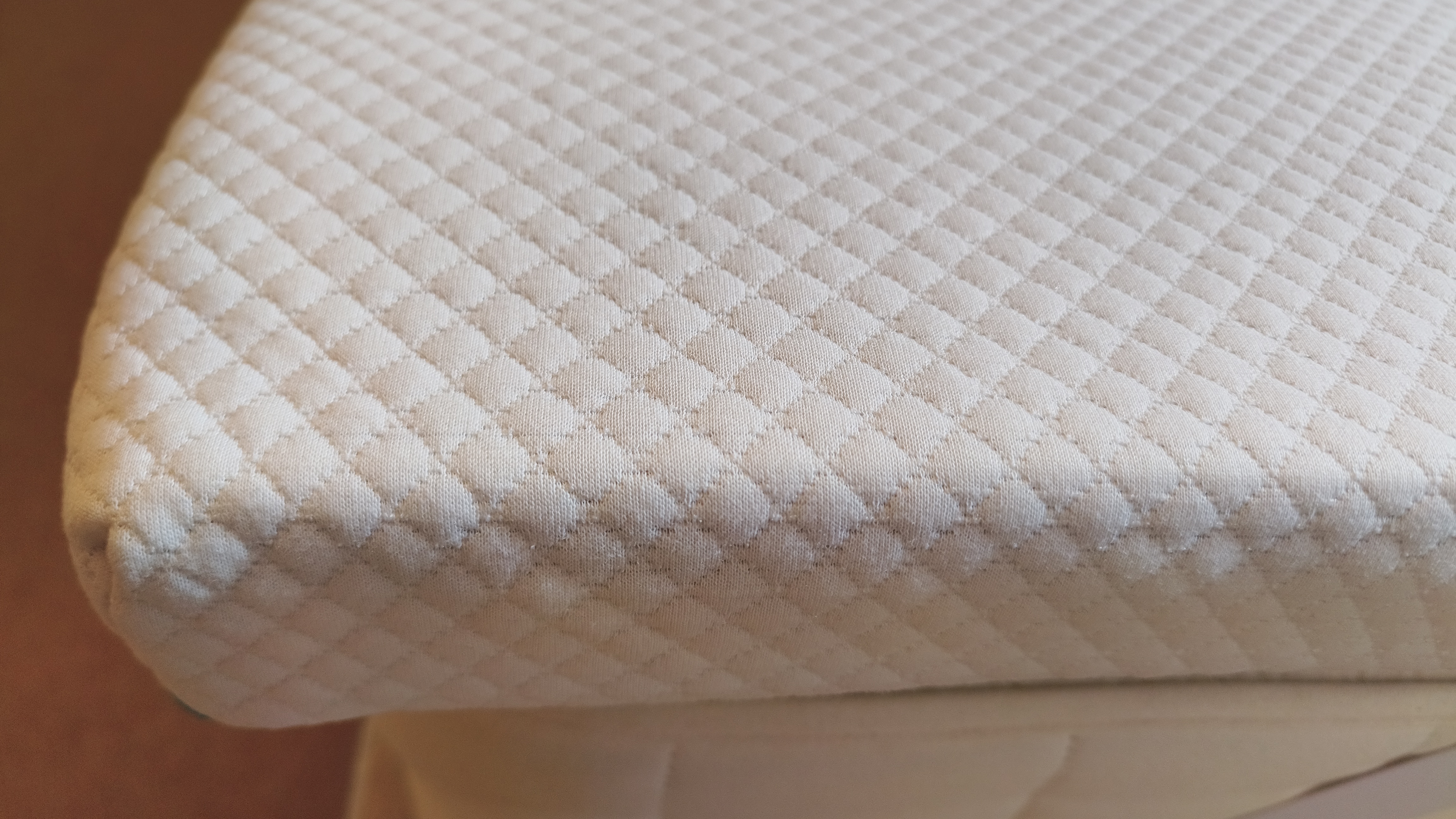 Close-up of the corner of the Simba Cool Foam Mattress Topper, showing the quilted knitted cover and the depth of the foam layers beneath.
