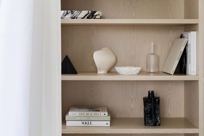 Minimalist bookshelf styling with white, marble and black objects