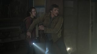Joel protège Ellie d'un ennemi hors champ dans la série télévisée The Last of Us