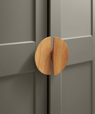 wooden circular handle on grey cupboard door
