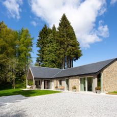 Driveway of single storey home next to established trees