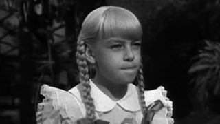 Patty McCormack as Rhoda Penmark scowling in The Bad Seed