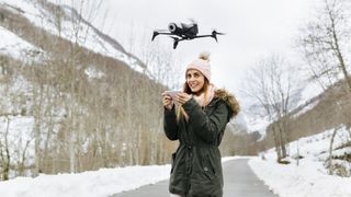 Drone Regulations: Everything you need to know: image shows woman flying drone in winter