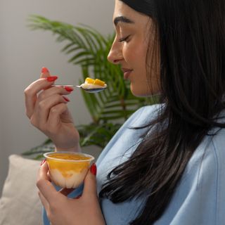 woman eating Dole pudding pot