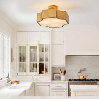 A gold geometric light fixture from Wayfair in a white kitchen