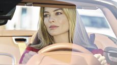 Margot Robbie driving a sportscar