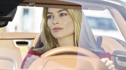 Margot Robbie driving a sportscar