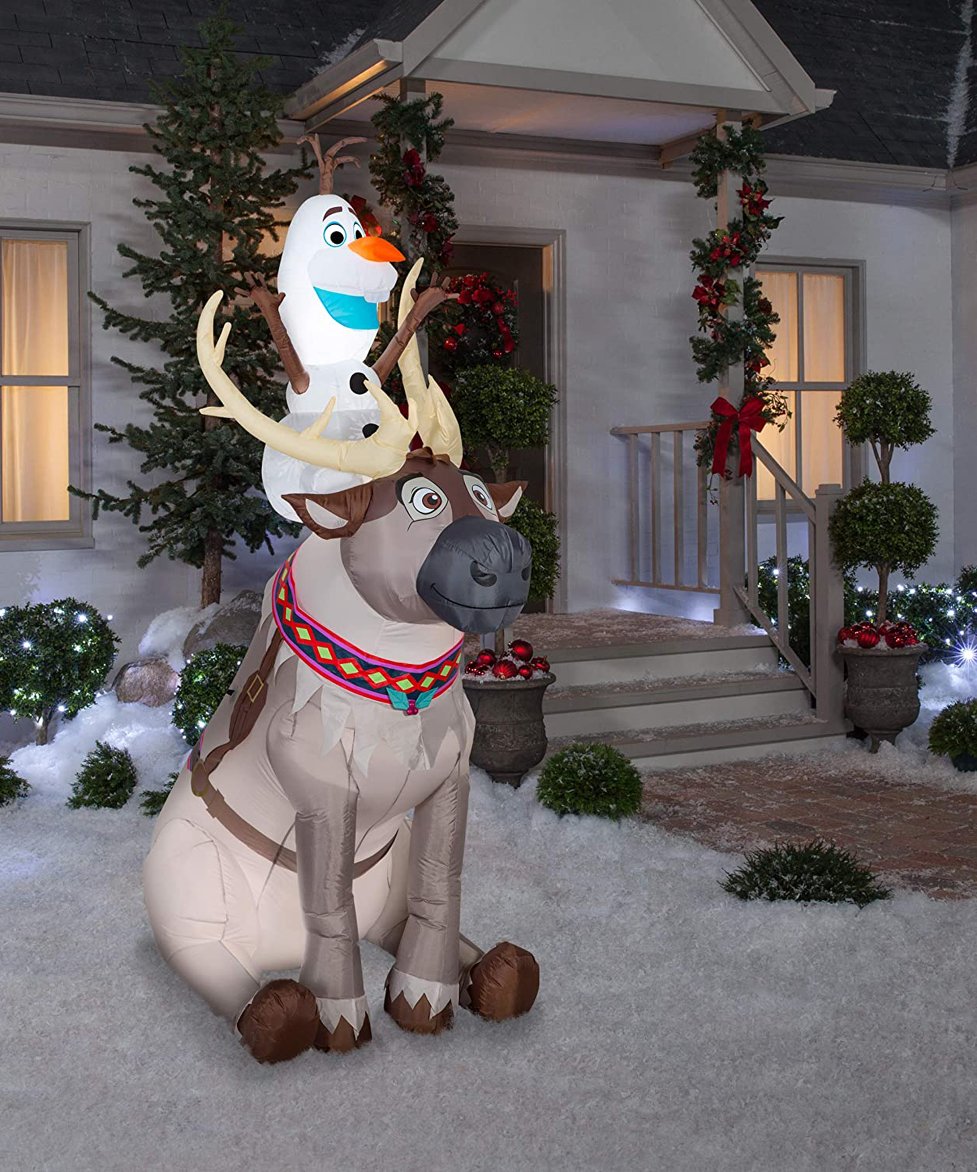 A Disney's Frozen inspired Xmas inflatable with Olaf snowman and Sven reindeer outside of house