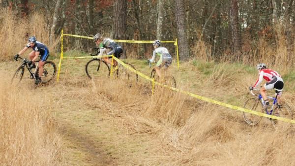 Laura Van Gilder (C-3 Althletes Serving Athletes) leading McConneloug, Bruno-Roy, and Elliot through the waist high grass
