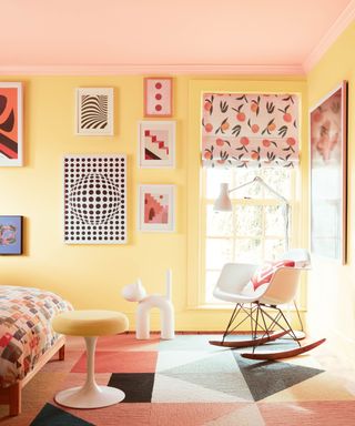 yellow and pink bedroom with gallery wall and rocking chair