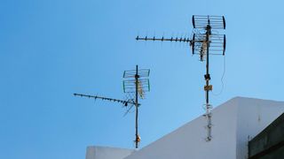 Two TV antennas atop of a house