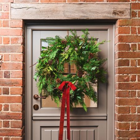 Christmas wreath on front door with red ribbon