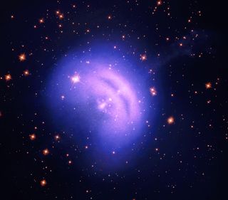 A glowing purple haze is seen in the center of the image. In the background, a wealth of stars and galaxies.