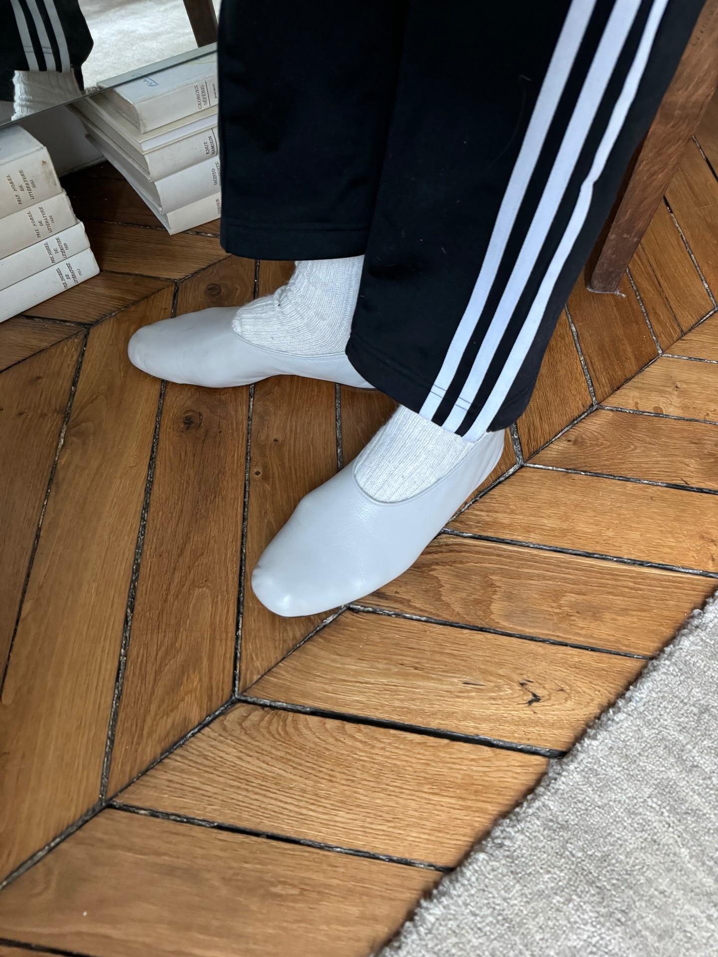 Woman in a track pants, socks, and ballet flats