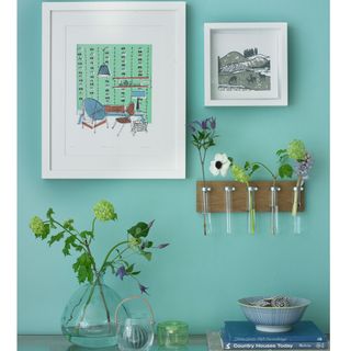 blue wall with picture frame and vase