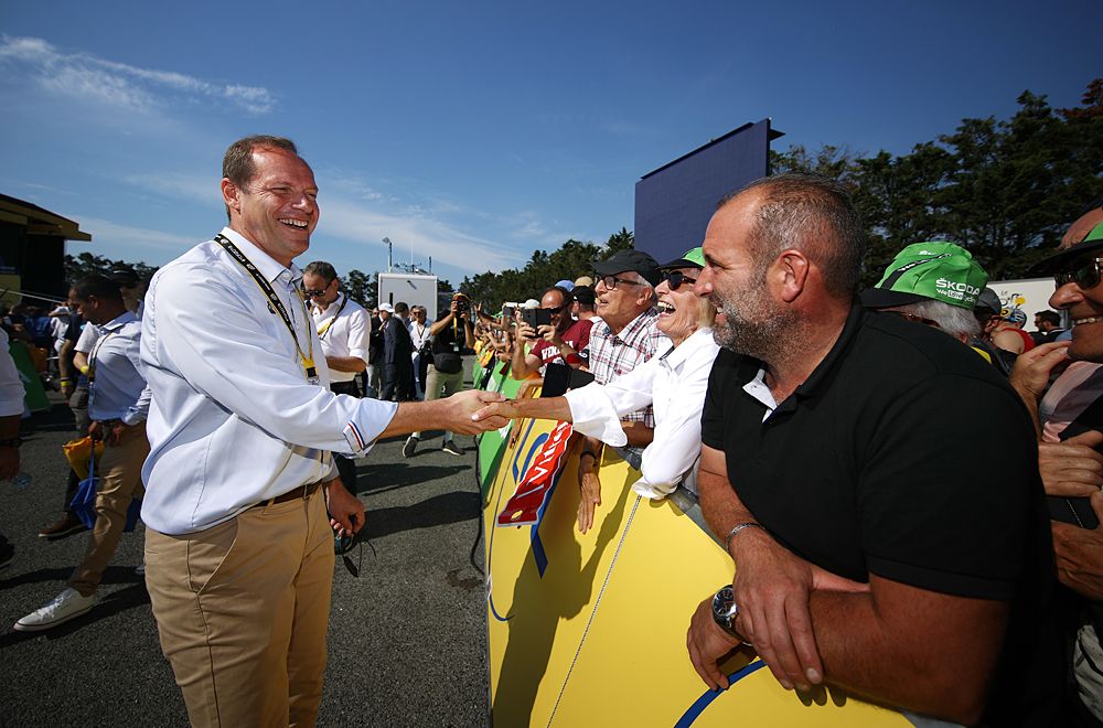 Tour de France director Christian Prudhomme shakes hands with fans at the start of stage 1