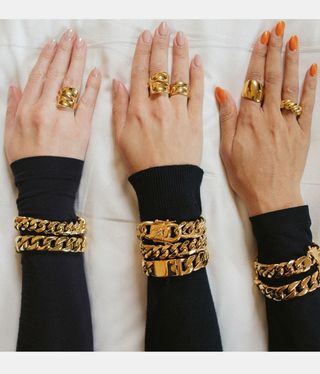 chunky gold bracelets and rings on models' arms and fingers