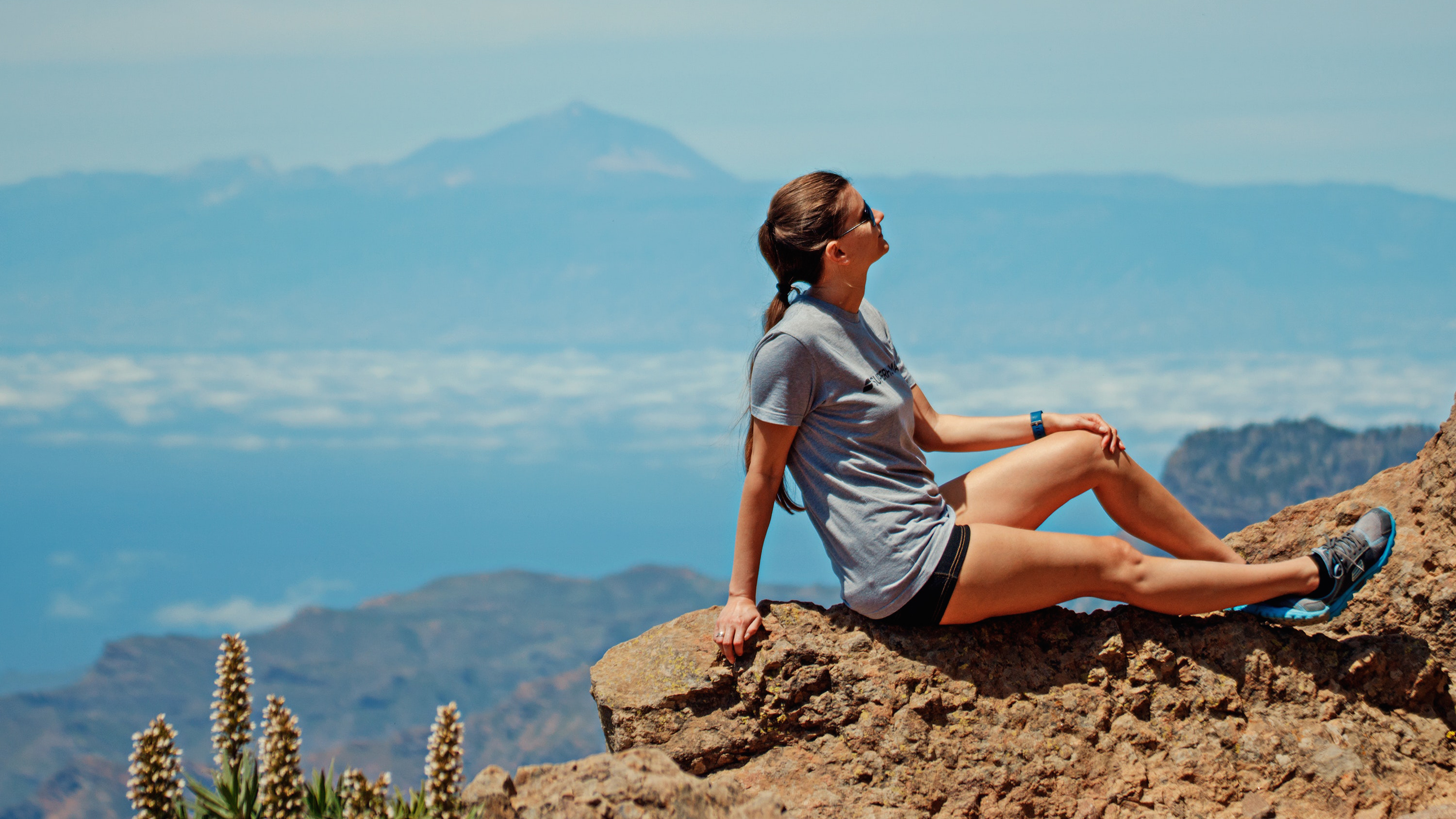 Best women's walking shoes: a woman sits on a rock overlooking a canyon