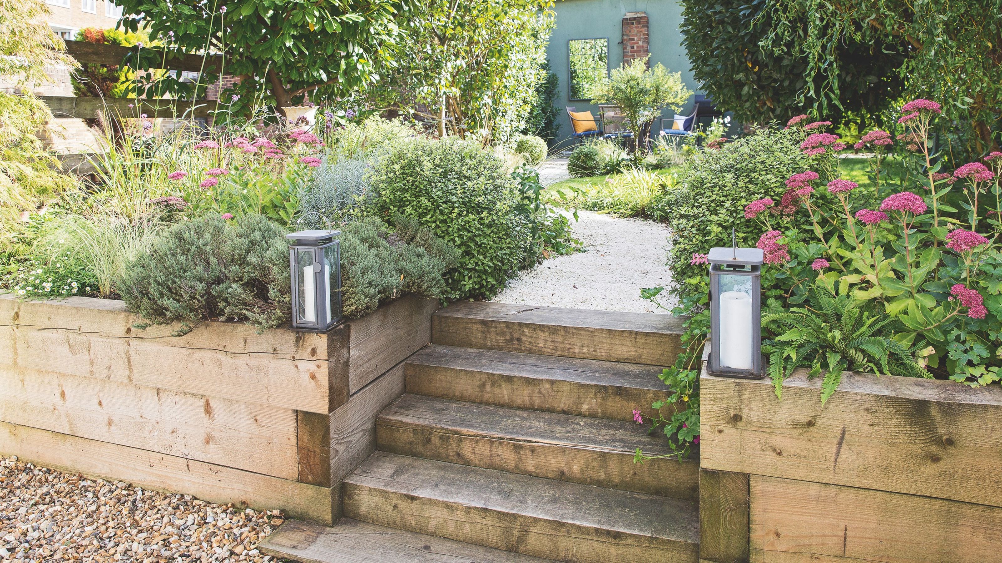 Wooden railway sleeper garden edging with lanterns and steps