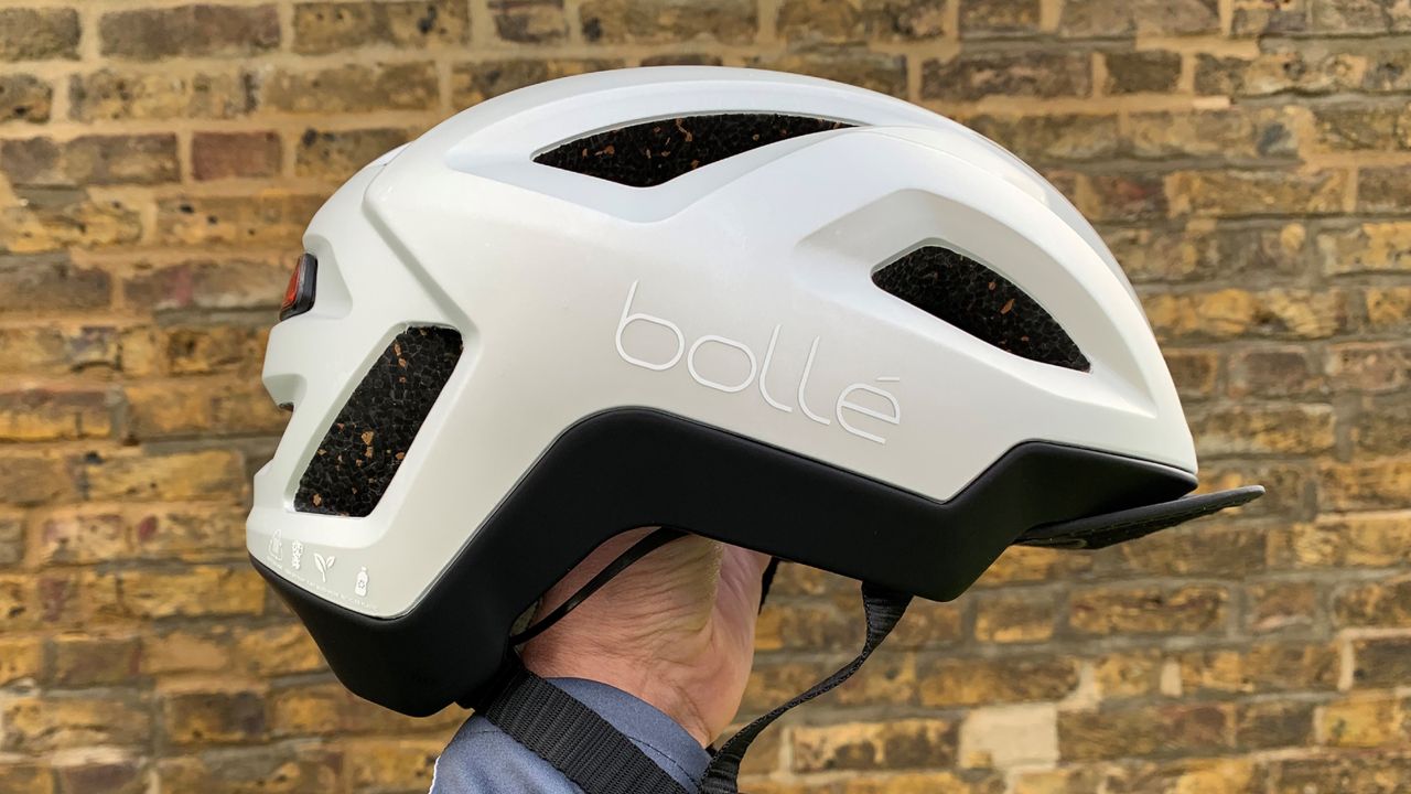 Male cyclist holding the Bollé Halo React MIPS helmet