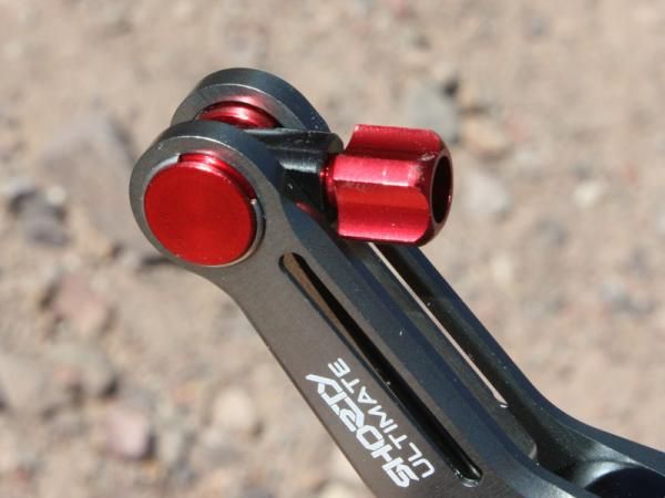 A barrel adjuster is integrated into the end of one arm.