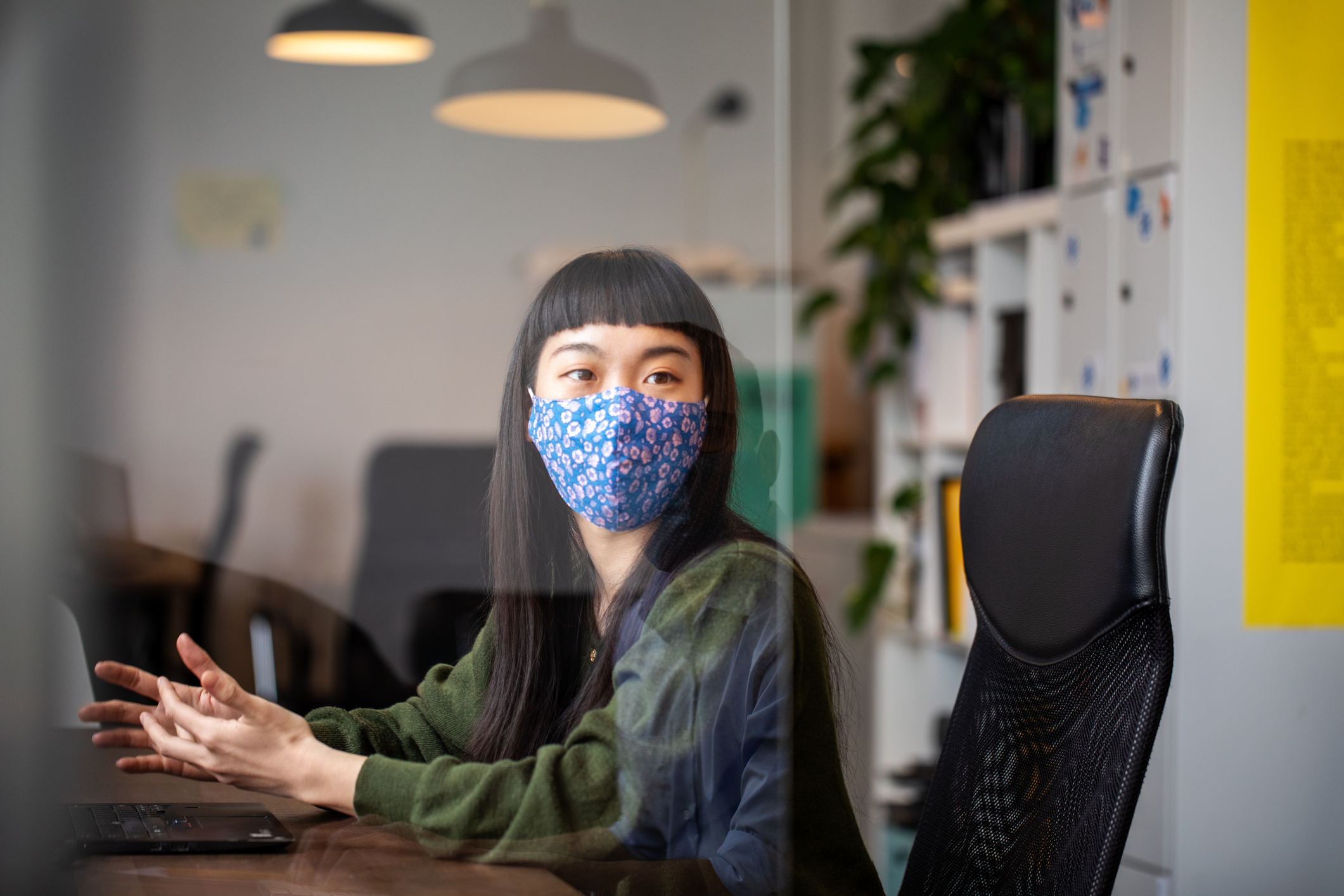 Woman wearing a face mask in the office as the living with Covid plan begins