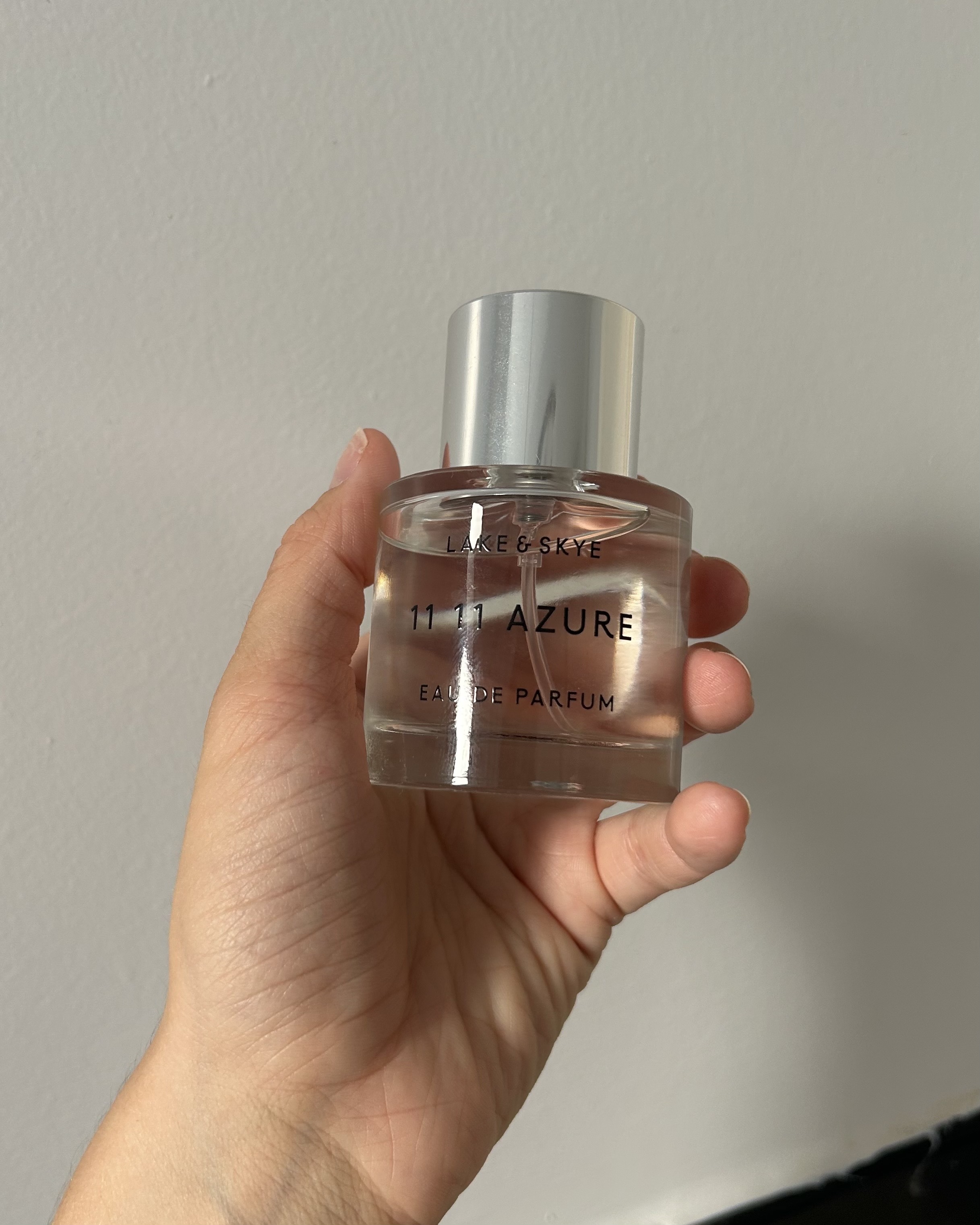 Alyssa Brascia holding the Lake & Skye 11 11 Azure Eau de Parfum.