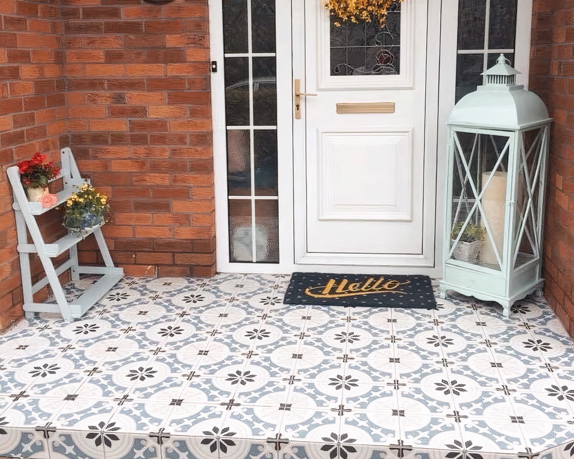 Porch area with light blue and gray patterned floor tiles, and 'Hello' door mat.