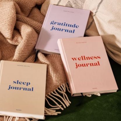 colourful wellness journals on green sofa with beige throw