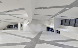 inside the white walled centre foyet, intersecting recessed lighting tracks and inlaid white stone pathways spill out on to the outside plaza in a combination of Belgian pierre bleue and grey concrete